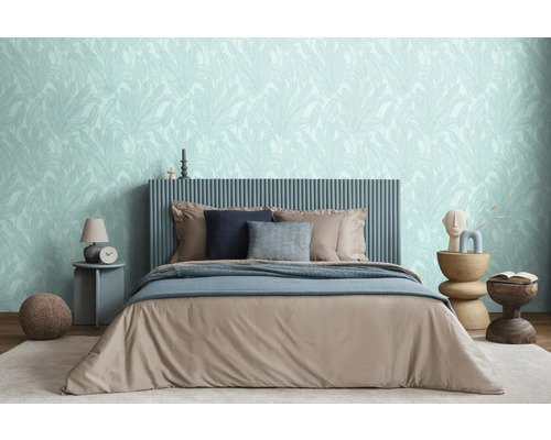 Slaapkamer met bed, nachtkastjes en behang met bladmotief voor een ontspannen sfeer.