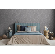 Slaapkamer met tweepersoonsbed, nachtkastje en patroonbehang voor een rustige sfeer.