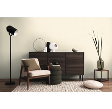 Woonkamer met fauteuil, dressoir, vloerlamp en decoratieve accessoires voor een gezellige sfeer