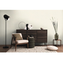 Woonkamer met dressoir, fauteuil, staande lamp en decoratie