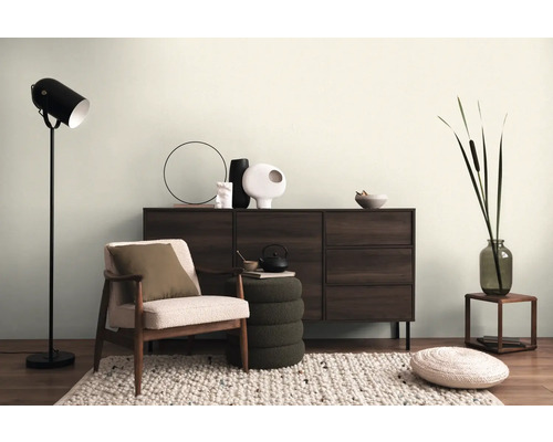 Woonkamer met dressoir, fauteuil, staande lamp en decoratie