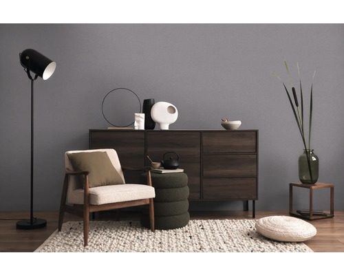 Woonkamer met fauteuil, vloerlamp en dressoir voor een gezellige sfeer