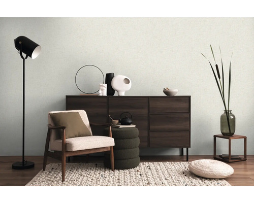 Woonkamer met fauteuil, dressoir, staande lamp en decoraties voor een gezellige sfeer.