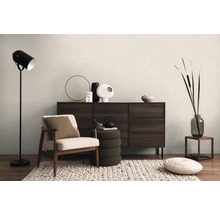 Interieur met fauteuil, staande lamp, dressoir en decoratieve elementen voor een gezellige woonsfeer.