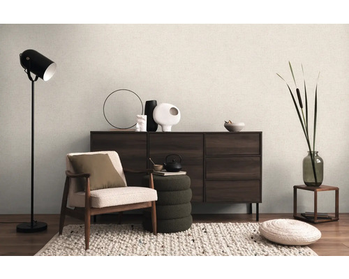 Interieur met fauteuil, staande lamp, dressoir en decoratieve elementen voor een gezellige woonsfeer.