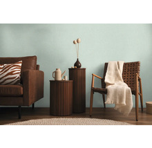 Woonkamer met bank, stoel en bijzettafels in een lichte sfeer