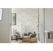 Woonkamer met patroonbehang, fauteuil en decoratie