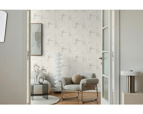 Woonkamer met patroonbehang, fauteuil en decoratie