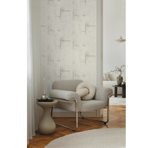 Woonkamer met gestructureerd behang en grijze fauteuil