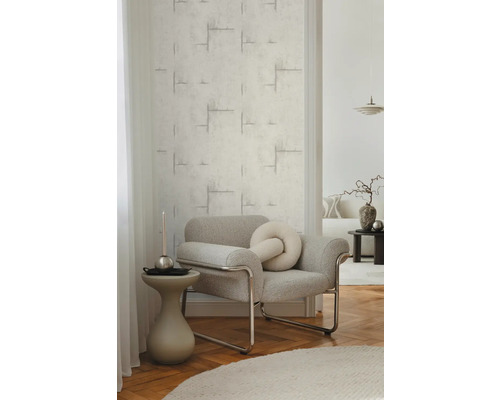 Woonkamer met gestructureerd behang en grijze fauteuil