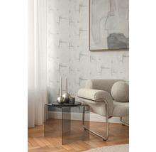 Woonkamer met fauteuil, bijzettafel en behang met patroon