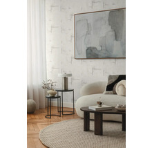 Woonkamer met bank, salontafel, bijzettafels, lamp en abstract schilderij