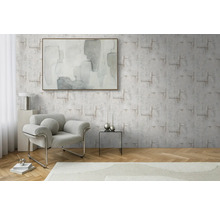 Woonkamer met patroonbehang, fauteuil en kunstwerk