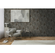 Woonkamer met fauteuil, tafel en decoratie tegen een gestructureerde wand