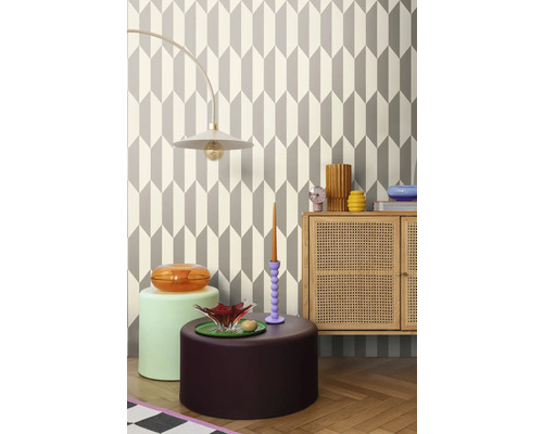 Woonkamer met geometrisch behang, lamp, dressoir en decoratieve objecten voor een stijlvol interieur.