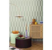 Decoratieve kamer met geometrisch behang, staande lamp, dressoir en bijzettafels.