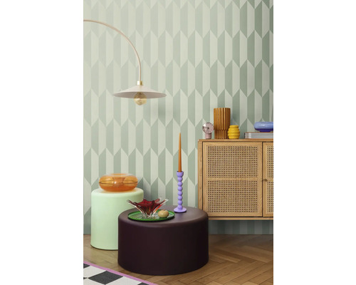 Decoratieve kamer met geometrisch behang, staande lamp, dressoir en bijzettafels.