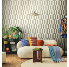 Woonkamer met geometrisch behang, bank, bijzettafel en decoratieve elementen voor een stijlvolle ambiance.