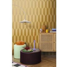 Inrichtingsvoorbeeld met een lamp, diverse tafels en een kast voor een behang met geometrisch patroon.