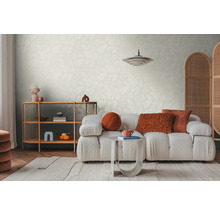 Lichte woonkamer met patroonbehang, bank, tapijt en houten rek