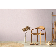 Decoratieve woonkameropstelling met stoel, vloerkleed, decoratie en bamboe ladder tegen een muur.