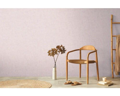 Decoratieve woonkameropstelling met stoel, vloerkleed, decoratie en bamboe ladder tegen een muur.