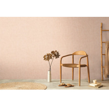 Decoratieve woonomgeving met houten stoel, tapijt en kamerplant tegen een subtiele muur