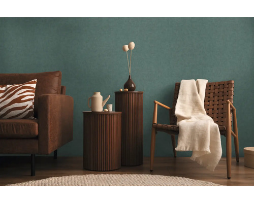 Woonkamer met bank, stoel, bijzettafels en decoratieve elementen voor een gezellige sfeer.