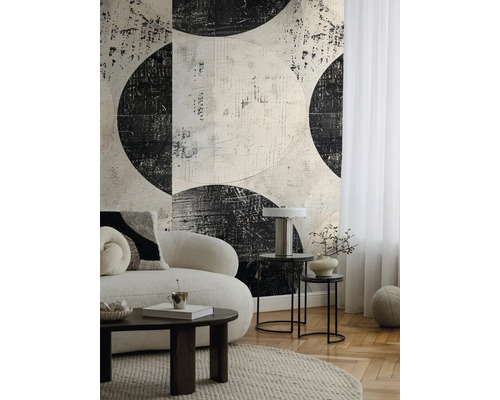 Woonkamer met bank, salontafel en behang met abstract cirkelpatroon.