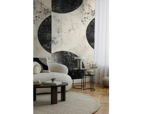 Woonkamer met een bank, een tapijt, bijzettafels en een gedessineerd behang