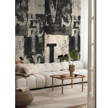 Woonkamer met bank, houten tafel en behang met krantmotief