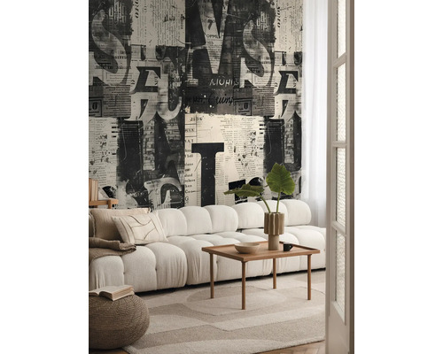 Woonkamer met bank, houten tafel en behang met krantmotief