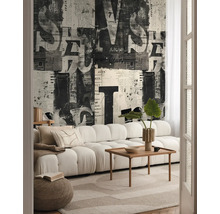 Woonkamer met bank, houten tafel, vloerkleed en behang met krantenpatroon
