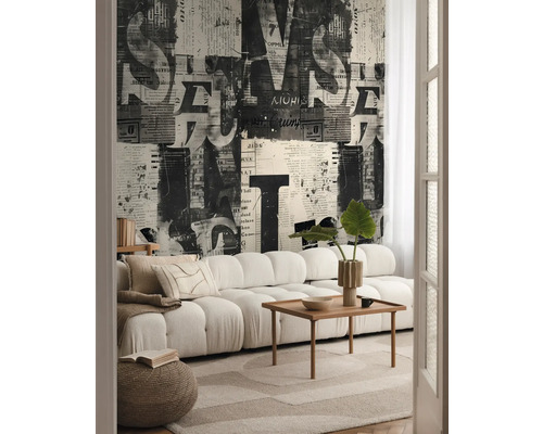 Woonkamer met bank, houten tafel, vloerkleed en behang met krantenpatroon