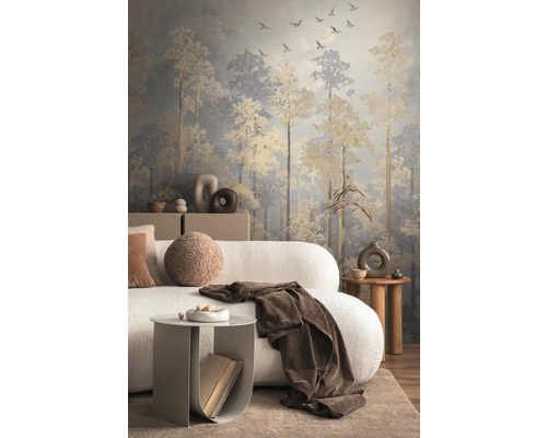 Woonkamer met behang dat een bos met vliegende vogels voorstelt, gecombineerd met een bank en bijzettafels.