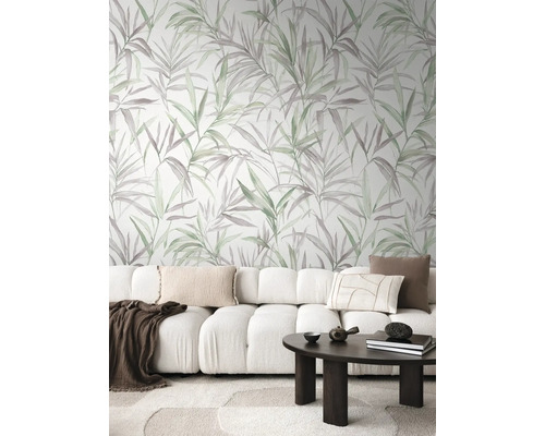 Woonkamer met bank, tafel en behang met plantenmotief