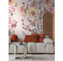 Woonkamer met bank, tafel, kussens en bloemenbehang voor een gezellige sfeer
