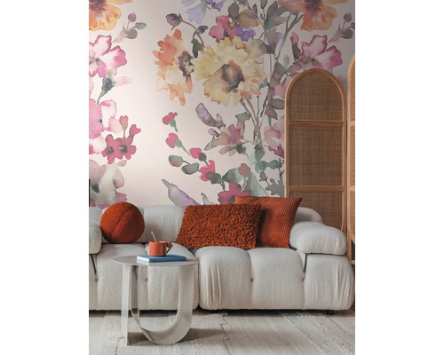 Woonkamer met bank, tafel, kussens en bloemenbehang voor een gezellige sfeer