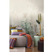 Woonkamer met bank, kussens, deken en behang met plantenmotief