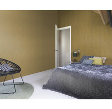 Slaapkamer met bed, stoel en muren met textuur