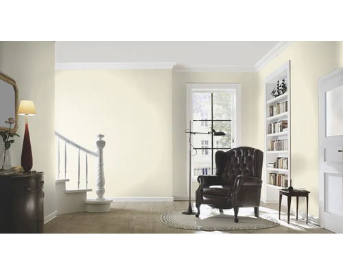 Lichte woonkamer met fauteuil, boekenkast en trap