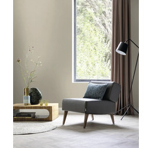 Woonkamer met fauteuil, tafel, vloerlamp en raam voor een heldere en georganiseerde sfeer.