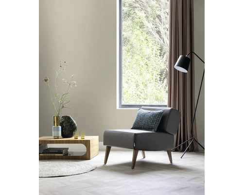 Woonkamer met fauteuil, tafel, vloerlamp en raam voor een heldere en georganiseerde sfeer.