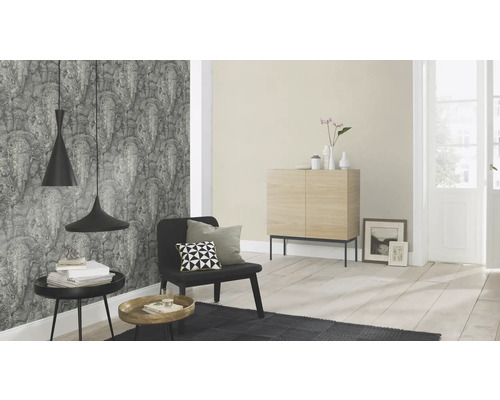 Woonkamer met patroonbehang, dressoir, fauteuil en hanglampen voor een stijlvolle ambiance