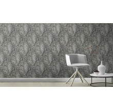 Scene met een behang bedrukt met olifantenreliëfs, een stoel en een tafel met decoratie