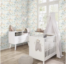Kinderkamer met bloemenbehang, commode en babybed.