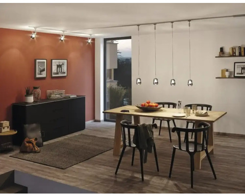 Eetkamer met houten tafel, zwarte stoelen, dressoir en verlichtingssysteem