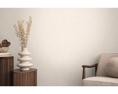 Scene met een fauteuil, een bijzettafel met bloemenvaas en decoratieve accessoires voor het woongedeelte