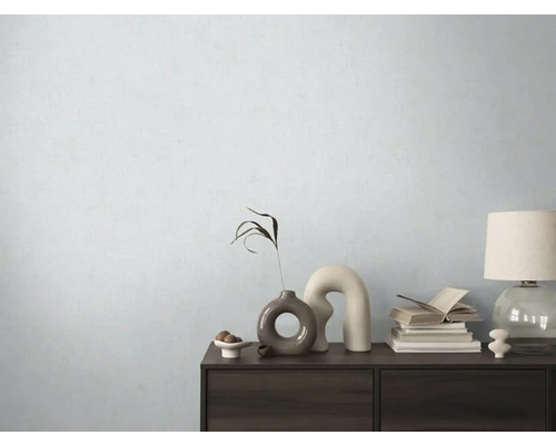 Decoratieve ladekast met vazen, boeken en lamp voor een lichte muur