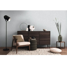 Woonkamer met dressoir, fauteuil, vloerlamp en decoratieve elementen voor een gezellige sfeer